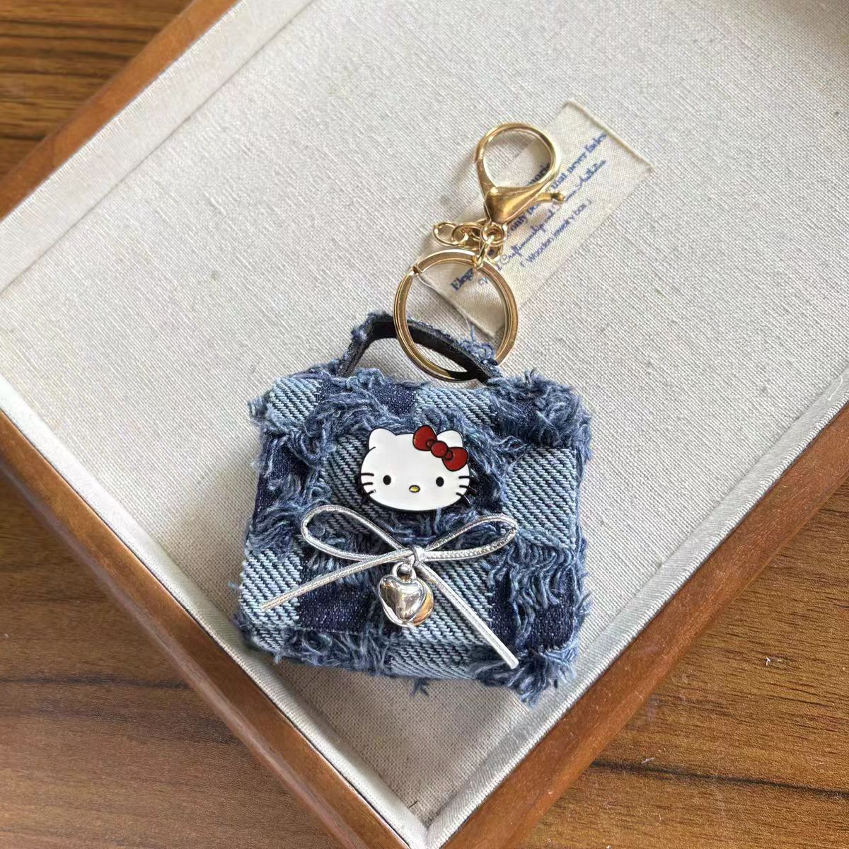 Hello Kitty AirPods Case Keychain – Denim Patchwork & Metallic Silver Protective Cover with Cute Bow & Bell Charm