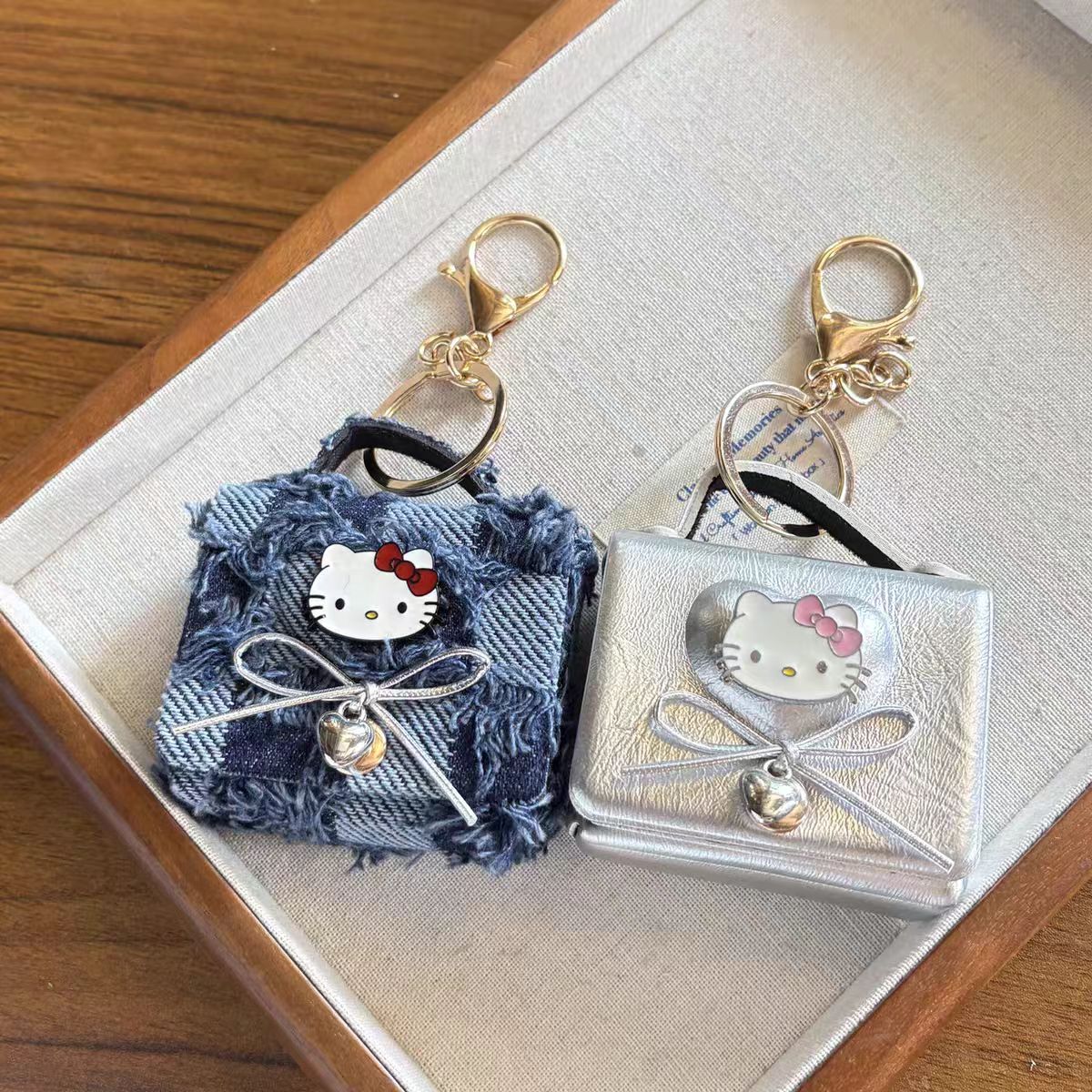 Hello Kitty AirPods Case Keychain – Denim Patchwork & Metallic Silver Protective Cover with Cute Bow & Bell Charm