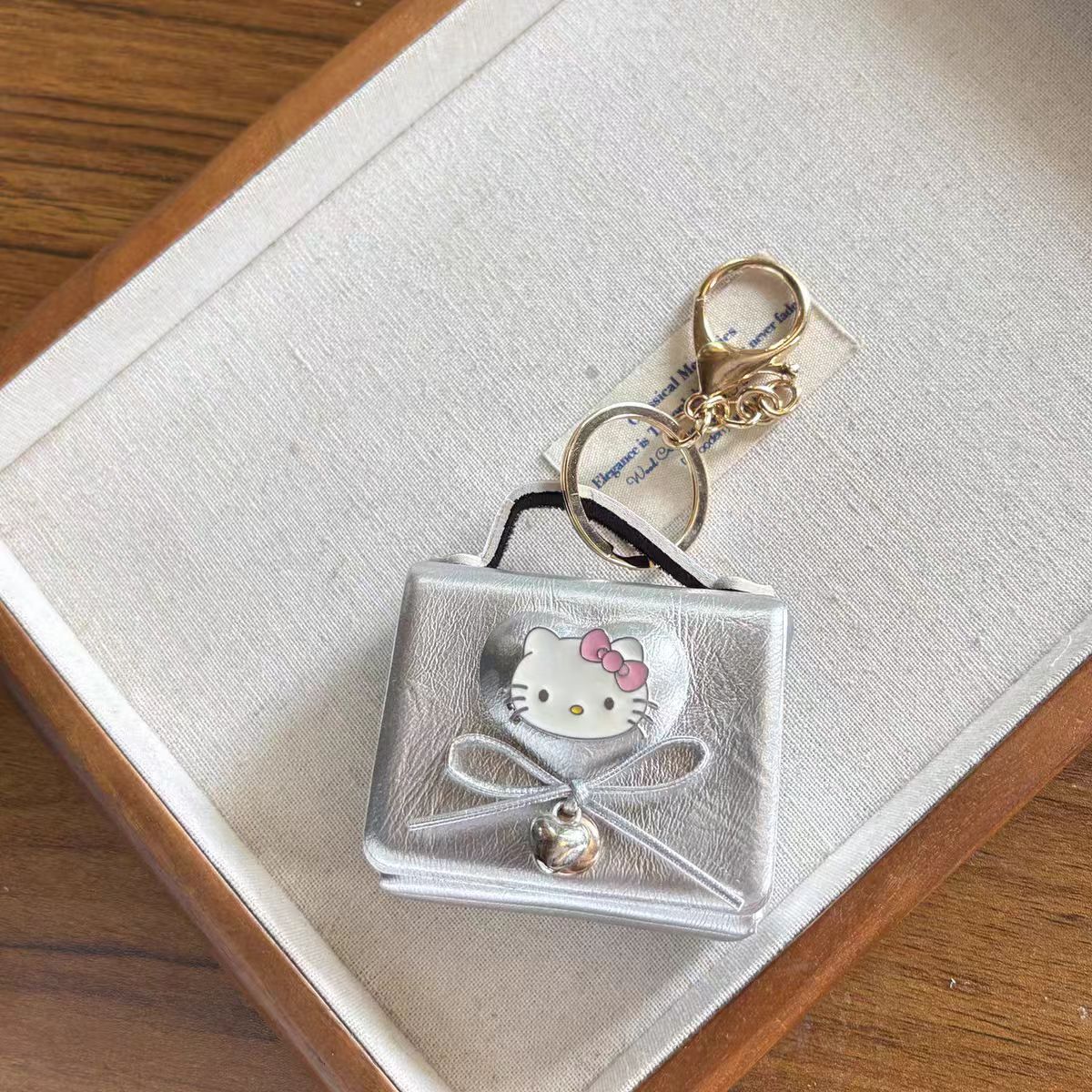 Hello Kitty AirPods Case Keychain – Denim Patchwork & Metallic Silver Protective Cover with Cute Bow & Bell Charm